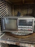 Front view showing the screen, frequency display panel, TV/Radio/Off button panel, and General Electric branding.