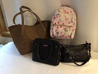 Full lot view showing all four bags: large brown tote, pink floral knapsack, black Roots handbag, black Danier leather purse.