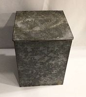 Front view of the galvanized metal milk box showing overall size and condition with embossed 'HOOD'S MILK' on lid.