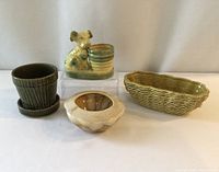 Four ceramic planters together: dog planter with round pot, small ribbed planter with saucer, basket-weave rectangular planter, round scalloped beige planter.