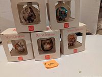 Five boxed Burger King collector Christmas balls showing variety of vintage-style Christmas illustrations.
