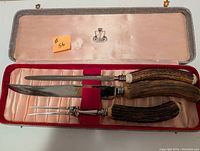 Full view of three piece carving set in red velvet-lined case with satin interior lid and crest.