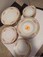 Full view of the Noritake China dishes arranged by type, showing floral pattern and gold border, confirming completeness of sets.