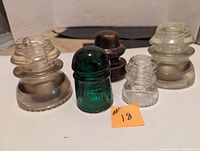 Front view of all 5 glass insulators showing color and height differences