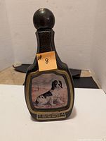 View of the front of the black textured Jim Beam bottle with painted Springer Spaniel image and stopper.