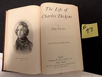 Open book showing title page and illustration of Charles Dickens, confirming author and title details.