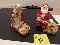 Front view of Mrs. Claus and Holiday Traditions Santa figurines showing detailed decorations and sizes.