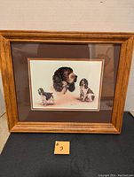 Framed Spaniel artwork showing three dogs with a wooden frame and brown matting, clear signature of Robert J May visible.