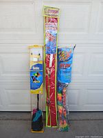 Three kites in original packaging photographed together showing full length