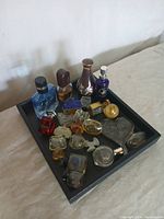 Tray of assorted vintage and modern perfume bottles in various shapes and colors.