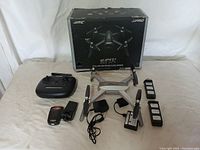 Full lot including drone, remote controller, two batteries, charger, and box.