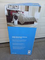 Full view of the NewAir evaporative cooler original box showing product image and room usage suggestion.