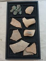Tray with pottery shards and possible turquoise stones in separate compartments