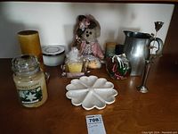 Photo showing candles, teddy bear, ceramic dish, metal pitcher, glass ornament and metal candle holder.