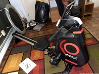 Full side view of the rowing machine showing frame, seat, rails and console in room setting