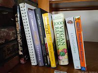 Books aligned on a shelf showing plant-based and vegan recipe cookbooks.