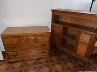Wooden four-drawer dresser with brass hardware and smooth varnished finish.