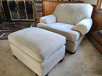 Side view of beige oversized armchair and matching ottoman in living room setting