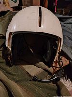 Front and interior view showing microphone boom, ear cups, and white outer shell with a central slot on top