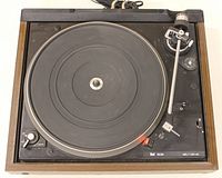 Top view of the turntable showing rubber platter mat, tonearm, and controls.
