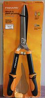 Fiskars shrub and plant pruning shears with ergonomic black and orange handles secured on orange packaging.