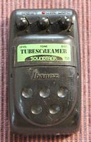 Top view of black Ibanez TS5 Soundtank Tubescreamer pedal showing the knobs for Level, Tone, and Distortion with green label and Ibanez embossing on footswitch area.