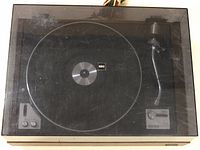 Top view of KEIO turntable with dust cover closed, showing the platter and tonearm under cover.