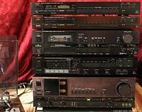 Five Luxman units stacked: tuner, tuner, cassette deck, surround amplifier, hybrid amplifier at bottom