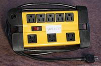 Top-down image of the Noma power bar laid on a surface, showing eight outlets, on/off switch, and power cord wrapped around the sides.