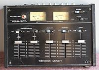 Top view of stereo mixer showing VU meters, input sliders for microphone, phono 1, phono 2, and tape, power and mode switches, headphone jack.