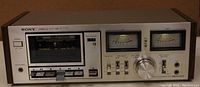 Front view of the Sony TC-K4A cassette tape player showing cassette compartment, control buttons, tape counter, VU meters, and volume knob.