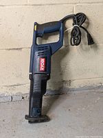 Side view of Ryobi RJ162V reciprocating saw showing Ryobi logo and power cord coiled on top.