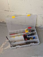 Plastic organizer box containing drill bits, Allen keys, and small tool accessories