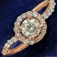 Close-up top view showing round center diamond and surrounding halo diamonds on split shank.