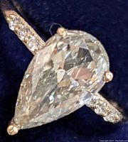 Top-down close-up of pear-shaped center diamond and diamond-pavé shoulders