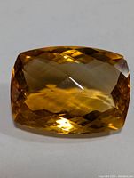 Top view of the rectangular cushion cut yellow-brown faceted gemstone showing the symmetrical faceting pattern.