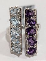 Front-facing photo showing two vertical rows of blue topaz and amethyst stones on a silver ring.