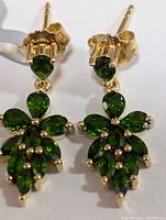 Front view of earrings showing pear-shaped chrome tourmaline stones arranged in flower and leaf patterns