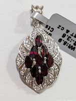 Front view of silver garnet and cubic zirconia pendant with tag showing 3.6ct and 5.9g weight