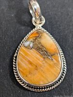 Close-up front view of silver teardrop Mohave turquoise pendant showing stone and silver border.