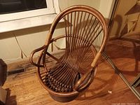 Front angled view of the bamboo swivel chair showing curved slat back, armrests, and circular bamboo base.