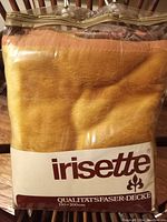 Photo of the packaged yellow golden synthetic blanket with the Irisette brand label showing the name and measurement