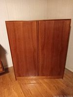 Front view of closed cabinet showing teak veneer doors