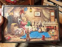 Front view of the artwork showing an illustrated postcard of rabbits in a bedtime story scene inside a handmade soldered metal frame.