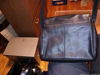 Front and exterior view of the black leather purse showing overall shape and condition