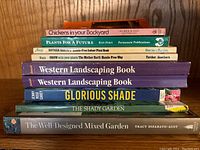 Stack of 8 gardening and landscaping books focusing on varied topics including backyard chickens and indoor plants.