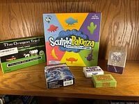 Photo showing six tabletop family games including The Oregon Trail Card Game, Sculptapalooza, Chrononauts, This is a Box of Yes, Raise the Stakes, and Where in the World