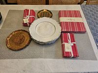 Overview of all items on table with plastic charger plates stacked, Venetian plates, napkins, and table cloth