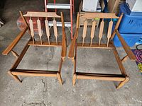 Two solid maple mid century side chair frames shown from front, no cushions attached.