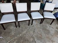 Four chairs shown front-facing on concrete floor